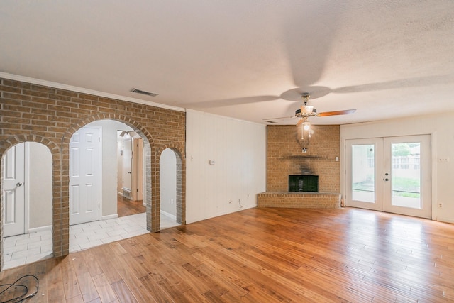 836 Springdale Rd, Bedford, TX 76021 - unfurnished living room with ceiling fan, arched walkways, light wood-type flooring, visible vents, and ornamental molding