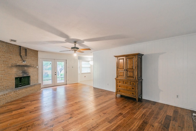 836 Springdale Rd, Bedford, TX 76021 - unfurnished living room with visible vents, wood-type flooring, a fireplace, ceiling fan, and french doors