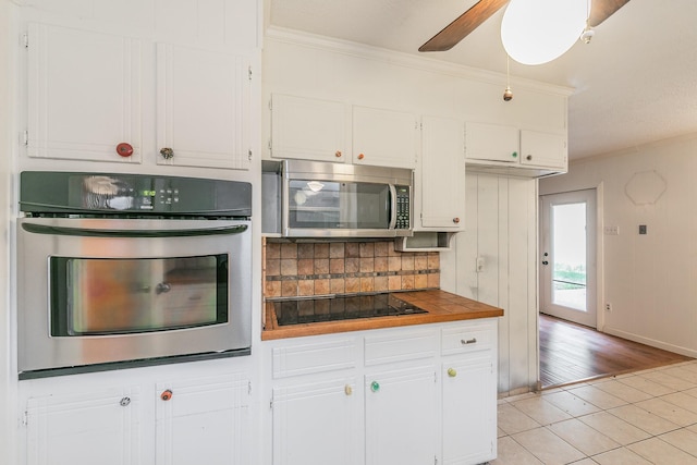 836 Springdale Rd, Bedford, TX 76021 - kitchen featuring white cabinets, stainless steel appliances, ornamental molding, and light tile patterned flooring