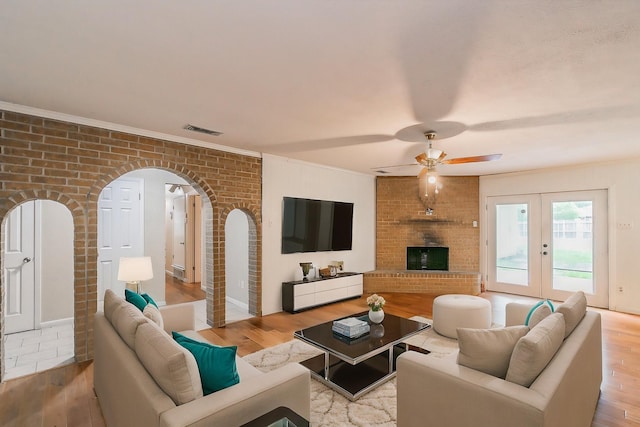 836 Springdale Rd, Bedford, TX 76021 - living area featuring ceiling fan, brick wall, visible vents, arched walkways, and wood finished floors