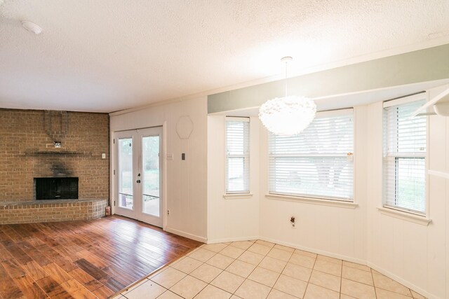 836 Springdale Rd, Bedford, TX 76021 - unfurnished living room featuring a fireplace, a textured ceiling, baseboards, wood finished floors, and ornamental molding
