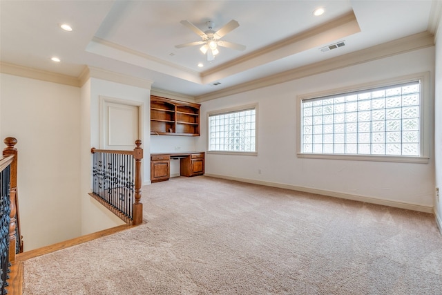 unfurnished living room with built in study area, recessed lighting, light colored carpet, a raised ceiling, and a ceiling fan