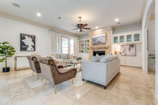 living area with ceiling fan, visible vents, a large fireplace, ornamental molding, and recessed lighting