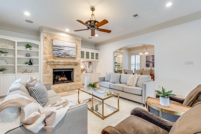 living area featuring visible vents, arched walkways, and ornamental molding