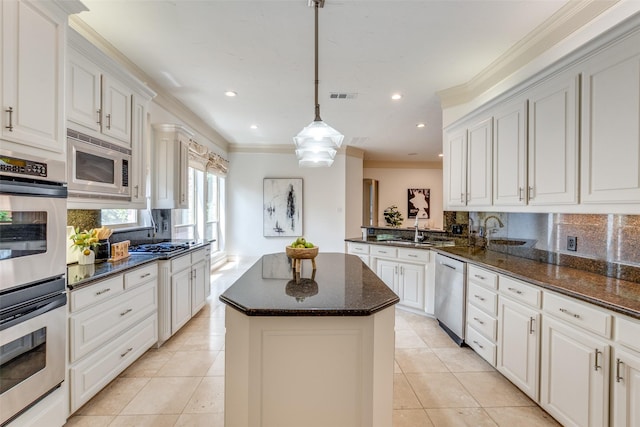 kitchen featuring visible vents, ornamental molding, a kitchen island, a sink, and appliances with stainless steel finishes