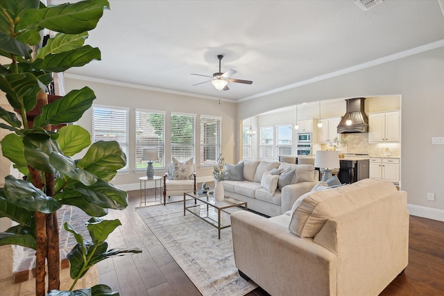 living room with crown molding, a ceiling fan, baseboards, and plenty of natural light