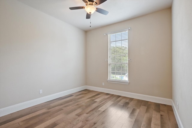 spare room featuring baseboards, a ceiling fan, and wood finished floors