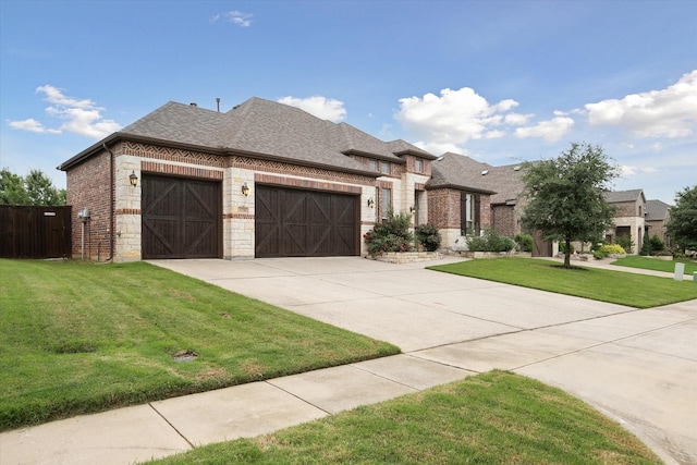 view of front of home featuring a front yard, roof with shingles, brick siding, concrete driveway, and an attached garage