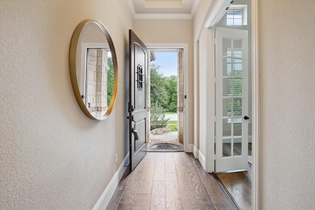 doorway to outside featuring a textured wall, a healthy amount of sunlight, and hardwood / wood-style floors