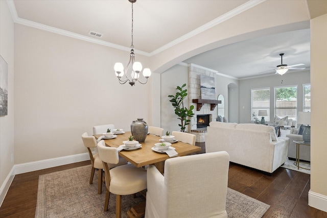 dining space with arched walkways, visible vents, dark wood-style floors, and a fireplace