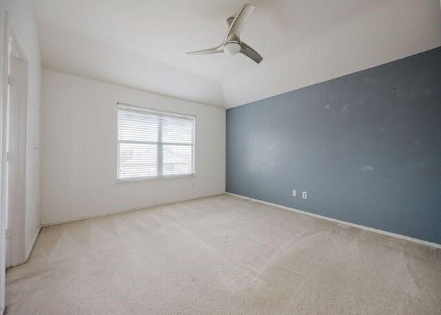 carpeted empty room with baseboards and a ceiling fan