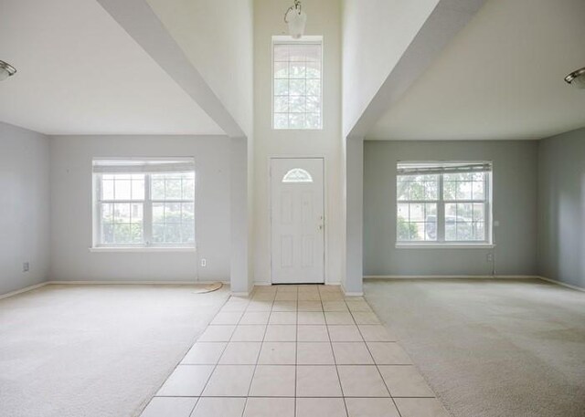 tiled entryway with baseboards and carpet flooring