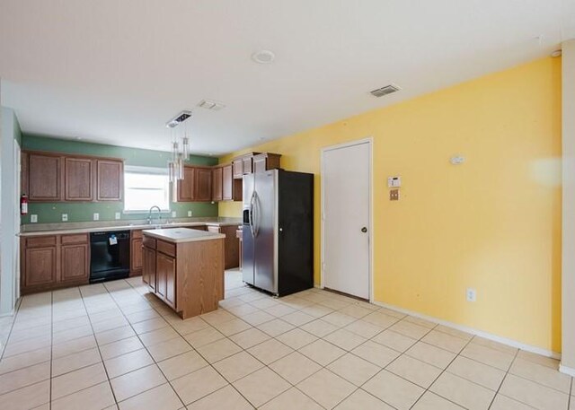 kitchen featuring light countertops, a center island, black dishwasher, stainless steel refrigerator with ice dispenser, and visible vents