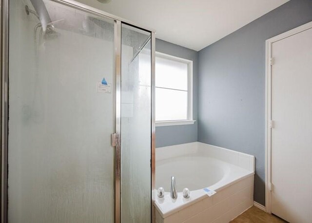 full bathroom with a bath and a stall shower