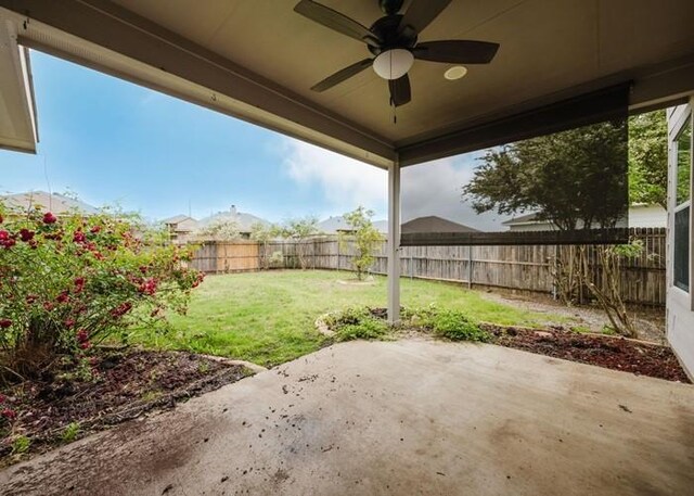 view of yard featuring a fenced backyard, ceiling fan, and a patio area