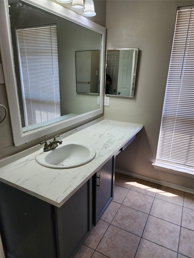 bathroom featuring vanity, baseboards, and tile patterned floors