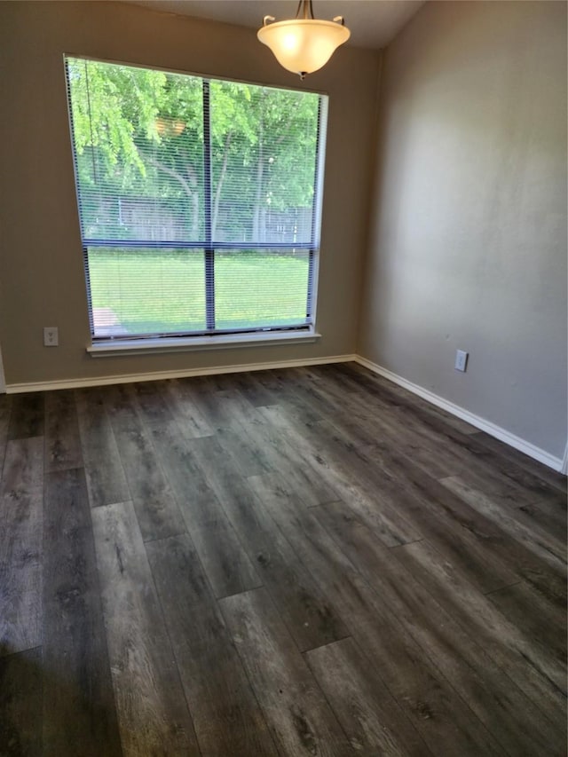 unfurnished dining area featuring dark wood-style flooring, baseboards, and a wealth of natural light