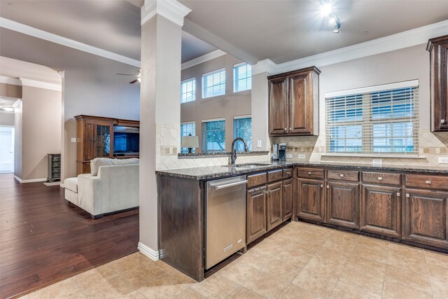 kitchen featuring crown molding, dark stone counters, arched walkways, appliances with stainless steel finishes, and backsplash
