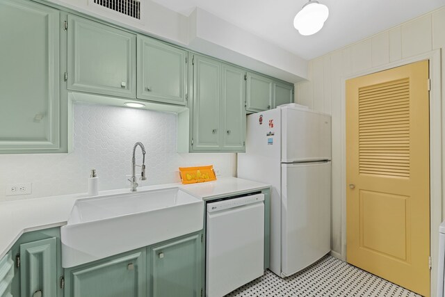kitchen featuring white appliances, light countertops, a sink, and green cabinets