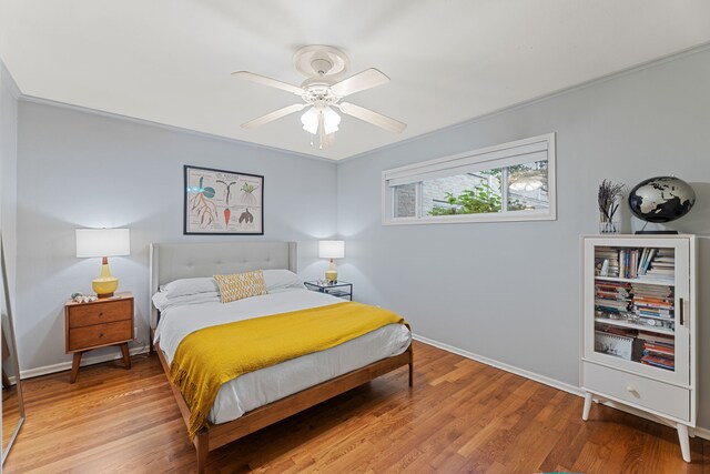 bedroom with baseboards, ceiling fan, and light wood-style flooring