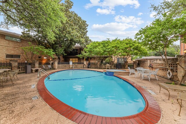 view of pool featuring fence, a patio, and outdoor dining space