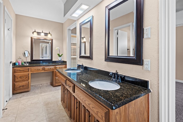 bathroom featuring double vanity, a sink, and tile patterned floors