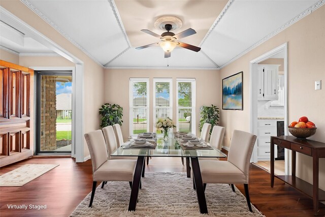 dining area featuring ornamental molding, lofted ceiling, wood finished floors, baseboards, and a ceiling fan