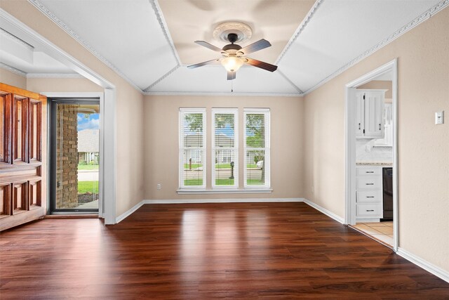interior space with crown molding, a ceiling fan, baseboards, vaulted ceiling, and dark wood-style floors
