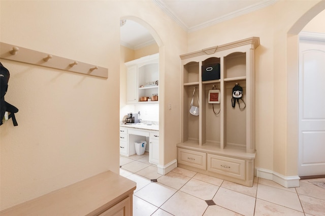 mudroom featuring crown molding, arched walkways, and light tile patterned floors