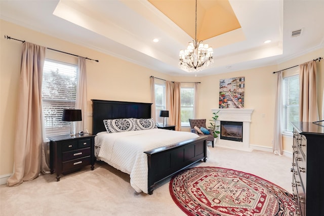 bedroom with light colored carpet, visible vents, multiple windows, and a raised ceiling
