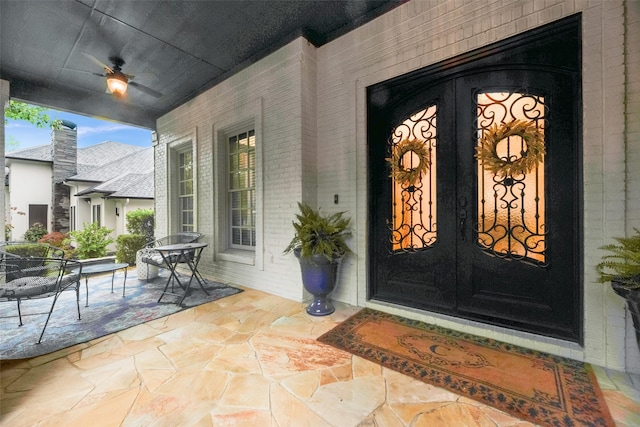view of exterior entry featuring outdoor dining area, french doors, and brick siding