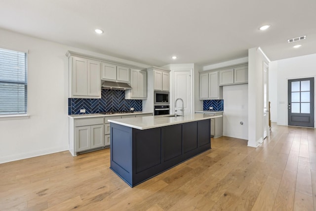 kitchen with appliances with stainless steel finishes, tasteful backsplash, a sink, baseboards, and light countertops