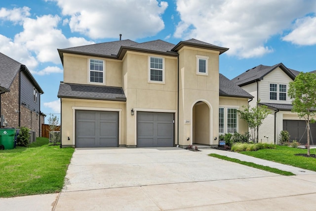 view of front of property with stucco siding, an attached garage, driveway, and a front yard