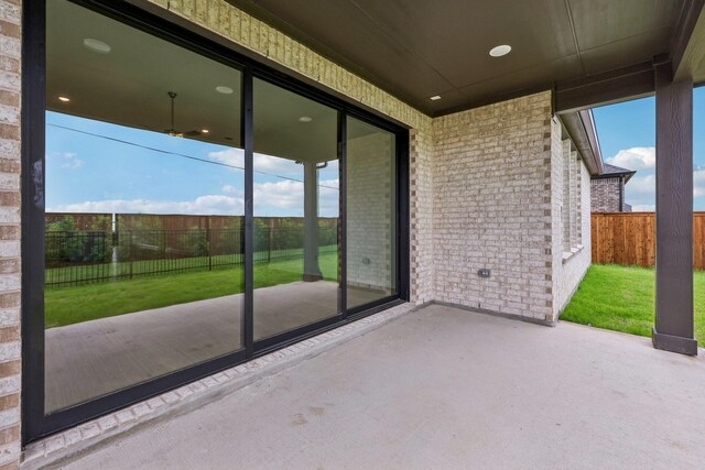 rear view of house featuring brick siding, a fenced backyard, a gate, a lawn, and a patio