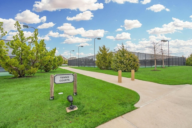 view of property's community featuring fence and a yard