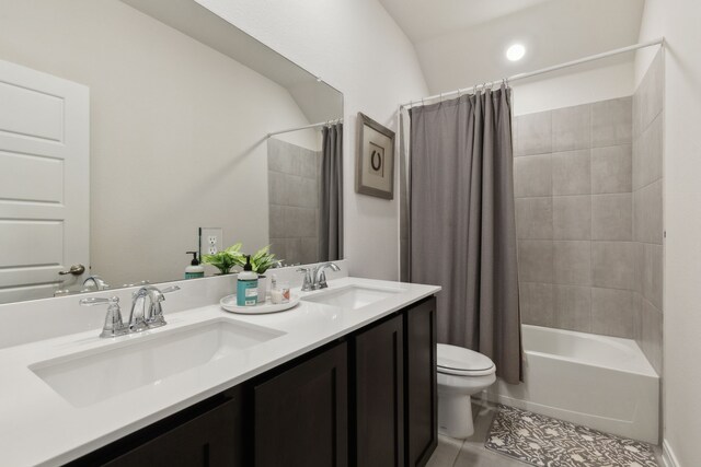 full bath featuring double vanity, a sink, tile patterned floors, and toilet