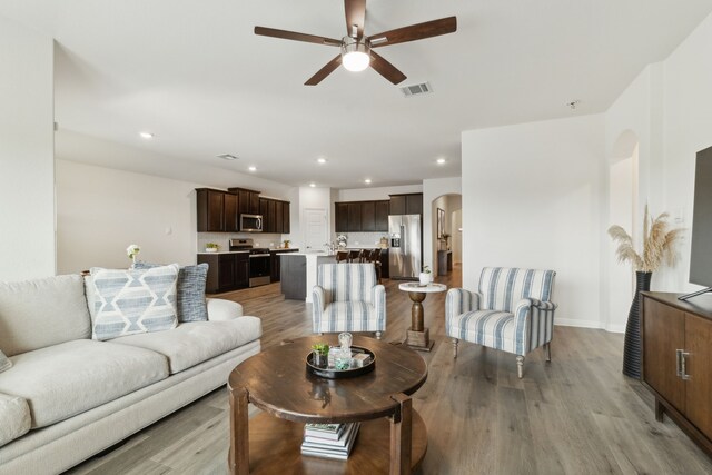 living room with ceiling fan, visible vents, baseboards, recessed lighting, and light wood-style flooring