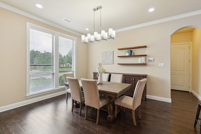 dining space with arched walkways, dark wood finished floors, baseboards, visible vents, and ornamental molding
