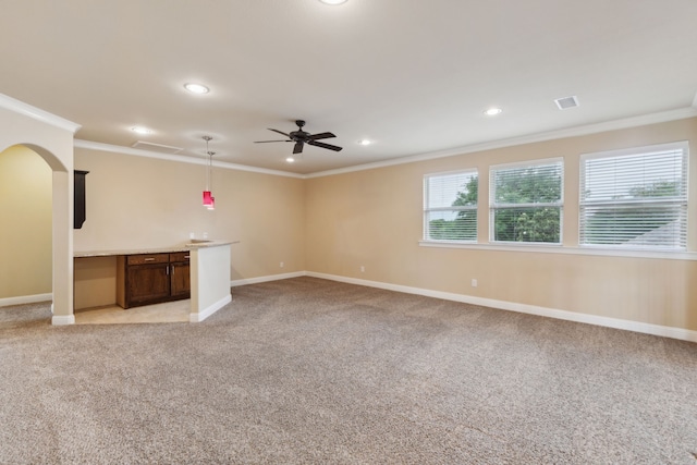unfurnished living room with crown molding, light carpet, baseboards, arched walkways, and a ceiling fan