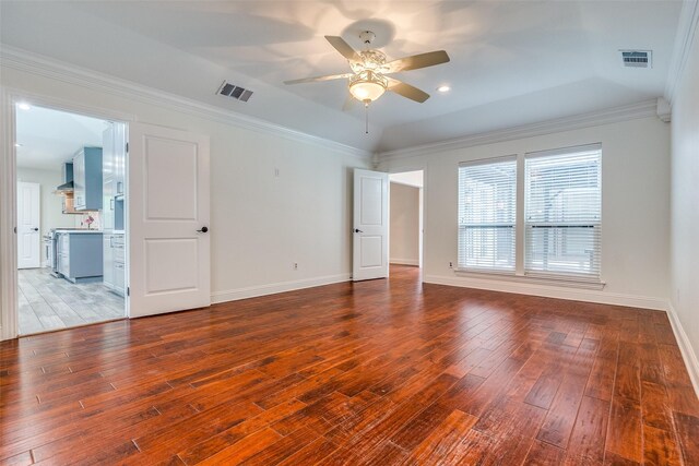 empty room featuring baseboards, a ceiling fan, hardwood / wood-style floors, and visible vents