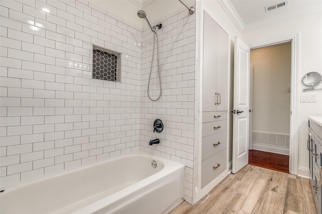 full bath featuring vanity, shower / bath combination, wood finished floors, visible vents, and ornamental molding