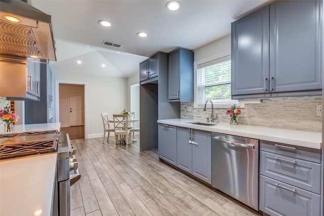 kitchen featuring backsplash, visible vents, a sink, stainless steel appliances, and light wood-style flooring