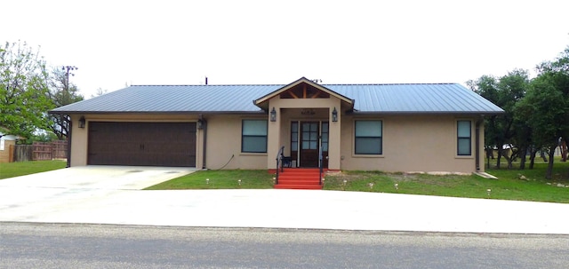 view of front of home featuring a garage, stucco siding, metal roof, and concrete driveway