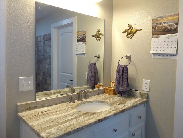 bathroom featuring vanity and a textured wall