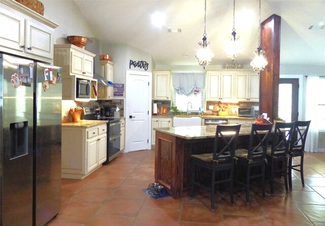kitchen featuring decorative backsplash, visible vents, appliances with stainless steel finishes, tile patterned flooring, and vaulted ceiling