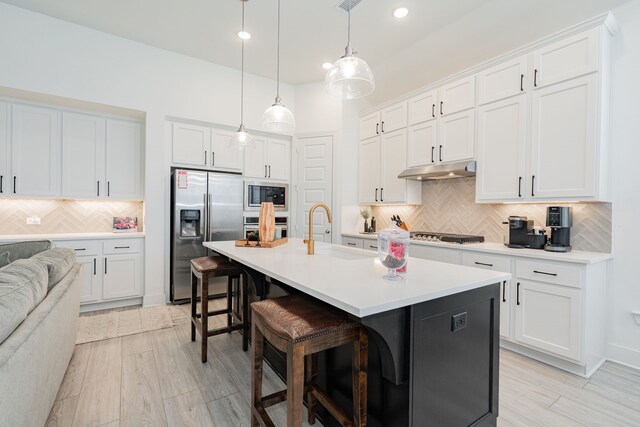 1925 Braided Mane Ave, Aubrey, TX 76227 - kitchen with a breakfast bar area, a sink, stainless steel appliances, backsplash, and under cabinet range hood