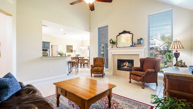 1230 Covina Ct, Allen, TX 75013 - living area featuring a tile fireplace, ceiling fan, light tile patterned floors, baseboards, and high vaulted ceiling
