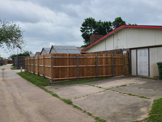 view of side of home featuring fence and a chimney