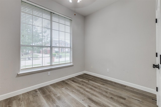 unfurnished room with baseboards and wood finished floors