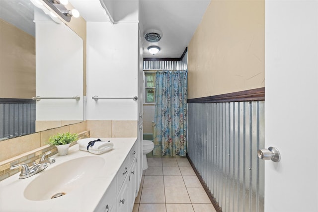 603 Sunnyvale Ln, Fairfield, TX 75840 - full bathroom with vanity, shower / bath combination with curtain, toilet, tile patterned floors, and a wainscoted wall